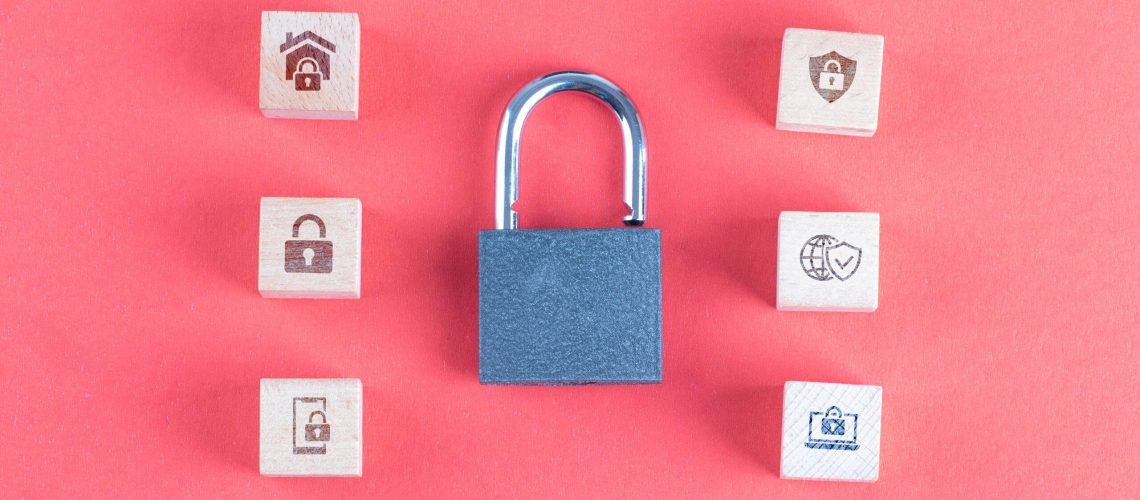 Security concept with lock, icons on wooden cubes on pink background flat lay.